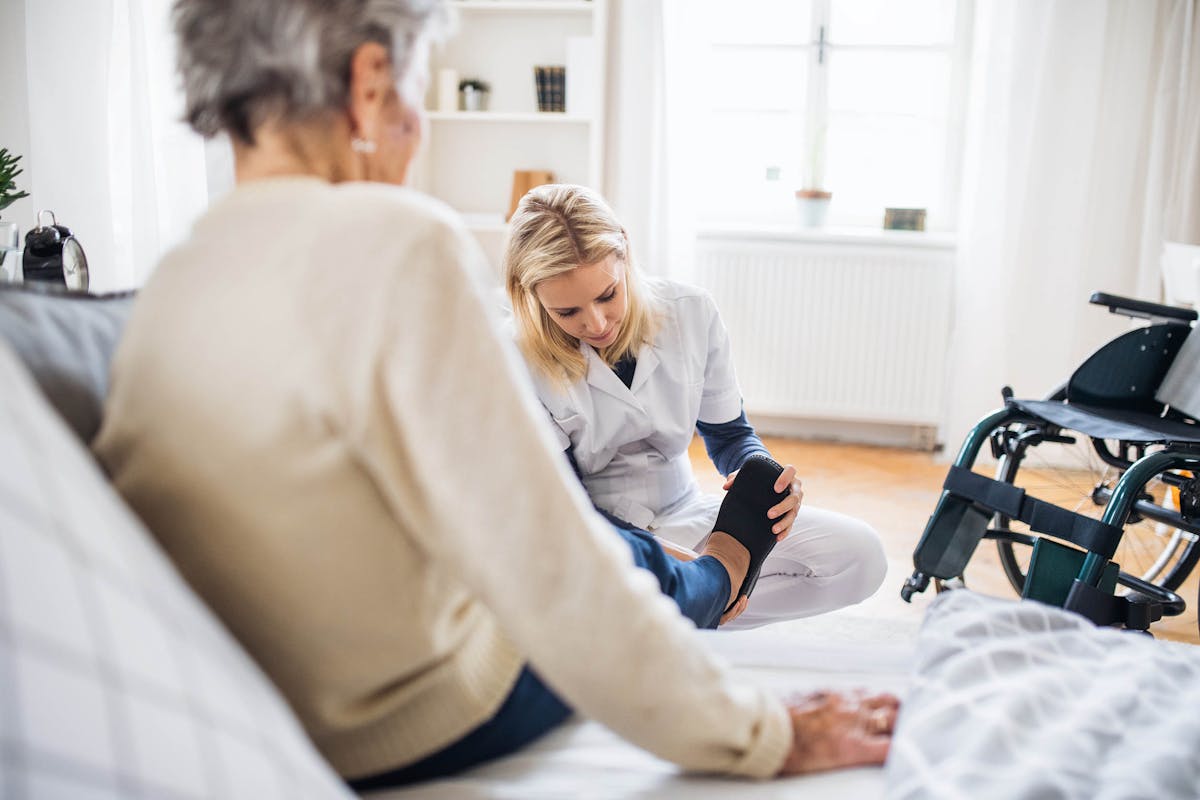 Carer helping eldery lady to put her shoes on